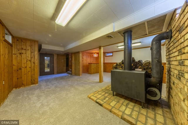 27042 Round Lake Rd, Bay Lake Twp, MN 56444 - finished below grade area with wooden walls, carpet flooring, and a wood stove