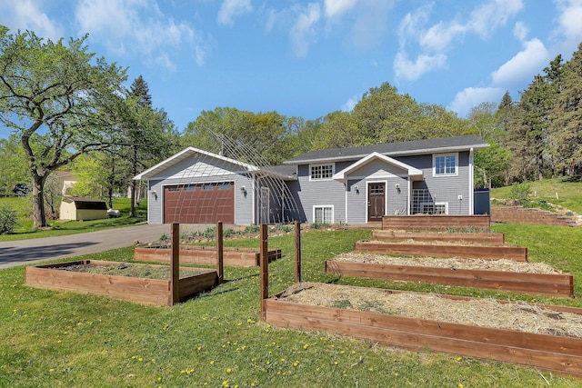 26063 County Road 2, Saint Joseph Twp, MN 56301 - bi-level home featuring a garden, a garage, a front lawn, and driveway