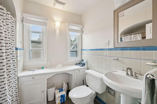 2613 Inglewood Ave S, Saint Louis Park, MN 55416 - bathroom with a wainscoted wall, curtained shower, and tile walls