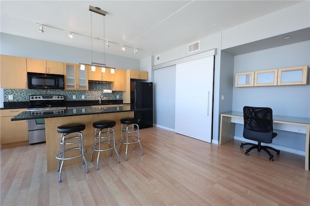 kitchen with backsplash, dark countertops, visible vents, and black appliances