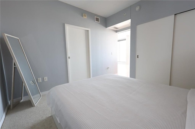 carpeted bedroom featuring visible vents