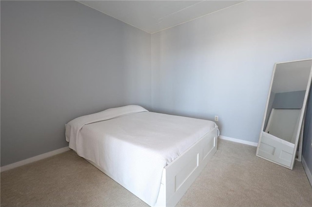 bedroom with baseboards and carpet