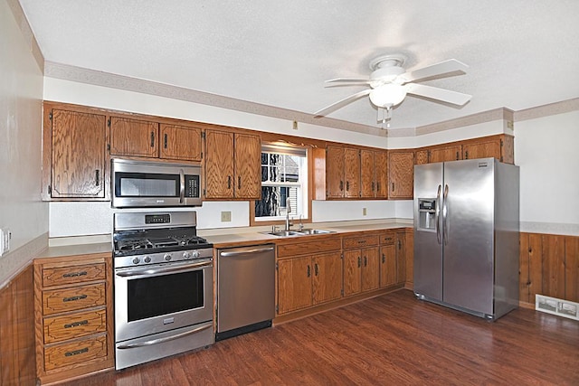 kitchen with ceiling fan, brown cabinetry, visible vents, appliances with stainless steel finishes, and a sink