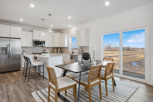 dining space with light wood-type flooring, recessed lighting, and visible vents