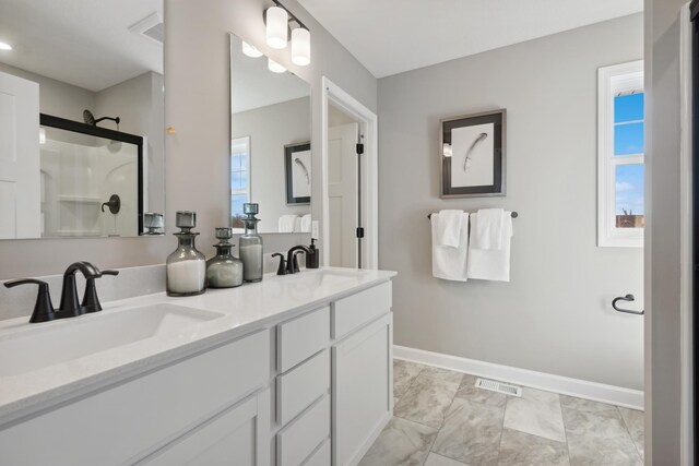 full bath featuring visible vents, a sink, marble finish floor, and a shower with shower door