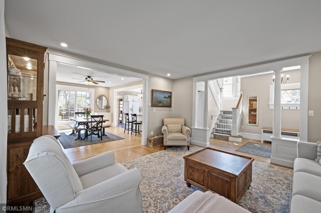 living room with stairs, decorative columns, wood finished floors, ceiling fan, and recessed lighting