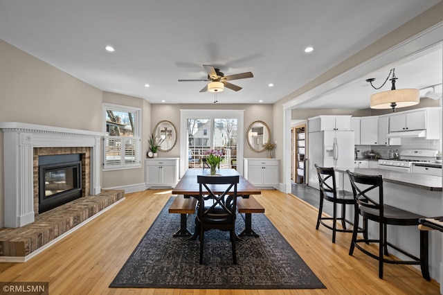 dining space featuring baseboards, recessed lighting, ceiling fan, and light wood-style flooring