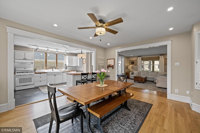 dining room with light wood-type flooring, a ceiling fan, a healthy amount of sunlight, and recessed lighting