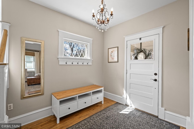 mudroom featuring baseboards, a notable chandelier, a healthy amount of sunlight, and wood finished floors