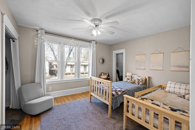 bedroom with baseboards, ceiling fan, and wood finished floors