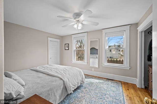 bedroom with baseboards, visible vents, ceiling fan, and light wood-style floors