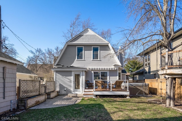 back of property featuring a gambrel roof, a wooden deck, a yard, and a fenced backyard