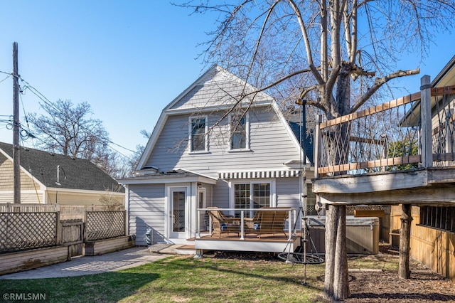 back of house featuring fence, a wooden deck, a yard, and a gambrel roof