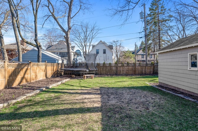 view of yard with a fenced backyard, a trampoline, and a residential view