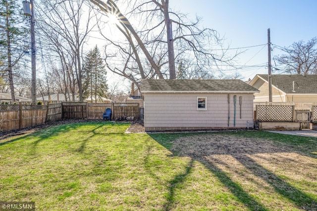 view of yard with a fenced backyard and an outbuilding