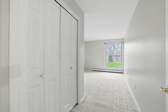 hall featuring carpet flooring, baseboards, and baseboard heating