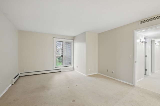 carpeted spare room with baseboards, visible vents, and baseboard heating