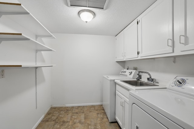 clothes washing area featuring cabinet space, separate washer and dryer, a textured ceiling, baseboards, and visible vents