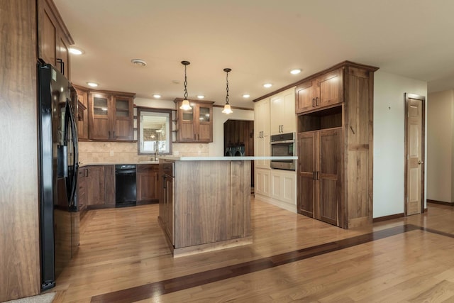 22694 Coney Island Dr, Clitherall, MN 56524 - kitchen with black appliances, light wood-style floors, backsplash, light countertops, and glass insert cabinets