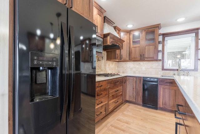 22694 Coney Island Dr, Clitherall, MN 56524 - kitchen with stainless steel appliances, a sink, brown cabinets, light countertops, and tasteful backsplash