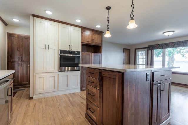 22694 Coney Island Dr, Clitherall, MN 56524 - kitchen featuring oven, light wood finished floors, light countertops, pendant lighting, and a kitchen island