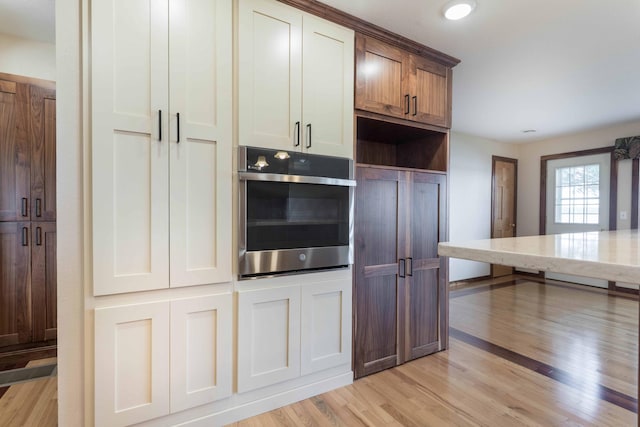 22694 Coney Island Dr, Clitherall, MN 56524 - kitchen featuring stainless steel oven, light wood-style flooring, and light stone countertops