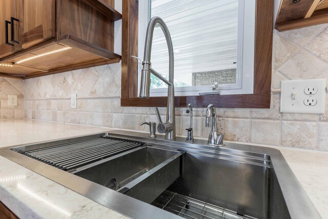 22694 Coney Island Dr, Clitherall, MN 56524 - kitchen view of tasteful backsplash, light countertops, brown cabinets, and a sink