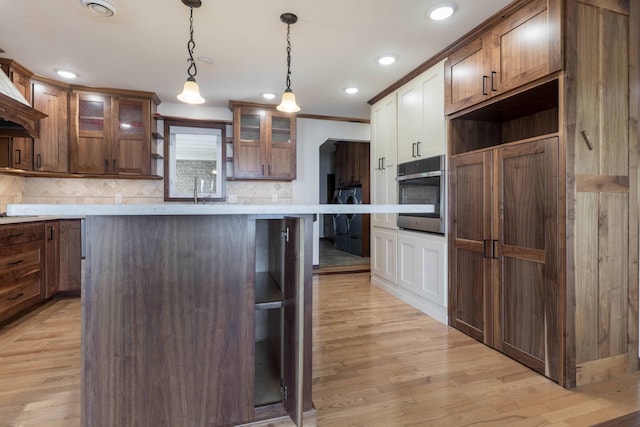 22694 Coney Island Dr, Clitherall, MN 56524 - kitchen with oven, decorative backsplash, glass insert cabinets, a center island, and light countertops