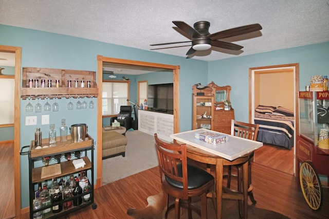 dining room featuring a ceiling fan, a textured ceiling, and wood finished floors