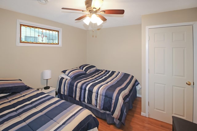 bedroom with baseboards, ceiling fan, and wood finished floors
