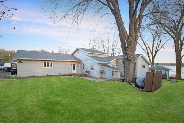 back of house featuring a lawn and a patio