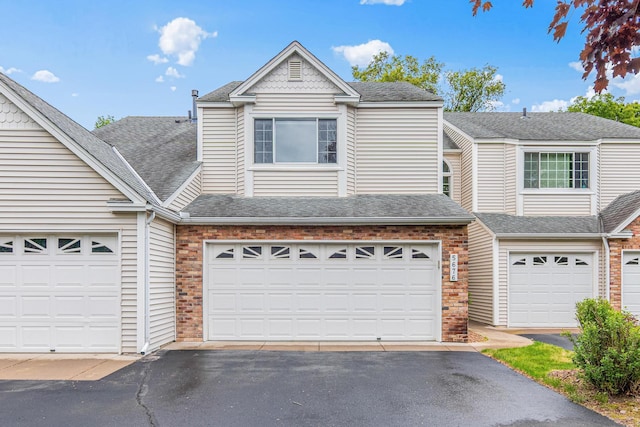 5676 Donegal Dr, Shoreview, MN 55126 - view of front of house with asphalt driveway, brick siding, and a shingled roof