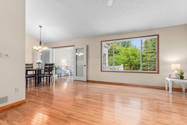 5676 Donegal Dr, Shoreview, MN 55126 - living room with light wood finished floors, a chandelier, baseboards, and a textured ceiling