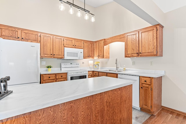 5676 Donegal Dr, Shoreview, MN 55126 - kitchen featuring white appliances, a sink, light countertops, light wood-type flooring, and a high ceiling