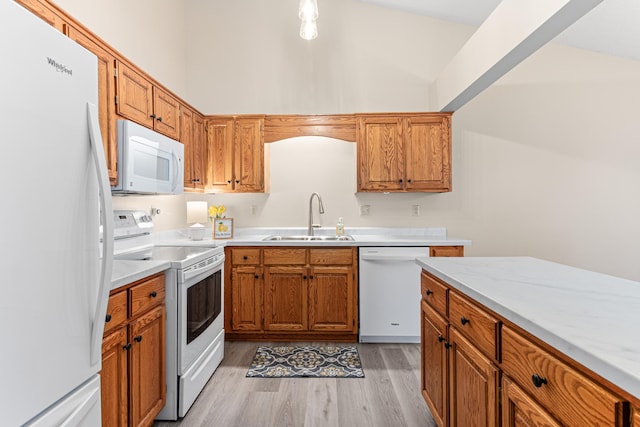 5676 Donegal Dr, Shoreview, MN 55126 - kitchen featuring white appliances, a sink, light countertops, light wood-style flooring, and brown cabinetry