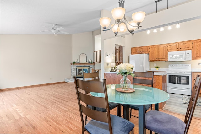 5676 Donegal Dr, Shoreview, MN 55126 - dining space featuring a ceiling fan, a chandelier, light wood-type flooring, a stone fireplace, and baseboards