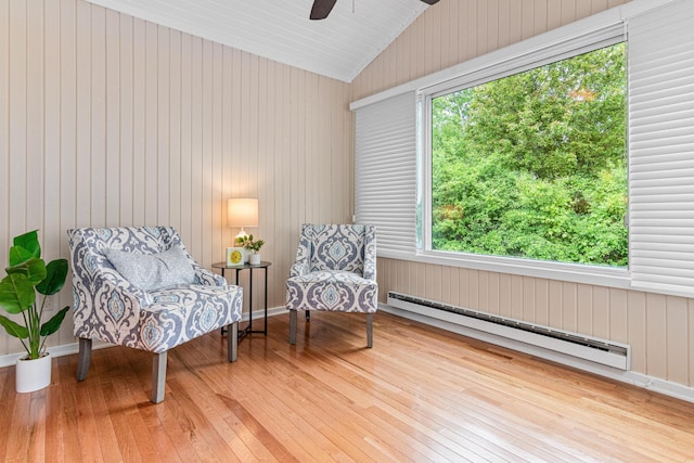 5676 Donegal Dr, Shoreview, MN 55126 - living area with a baseboard radiator, hardwood / wood-style flooring, vaulted ceiling, ceiling fan, and wood walls