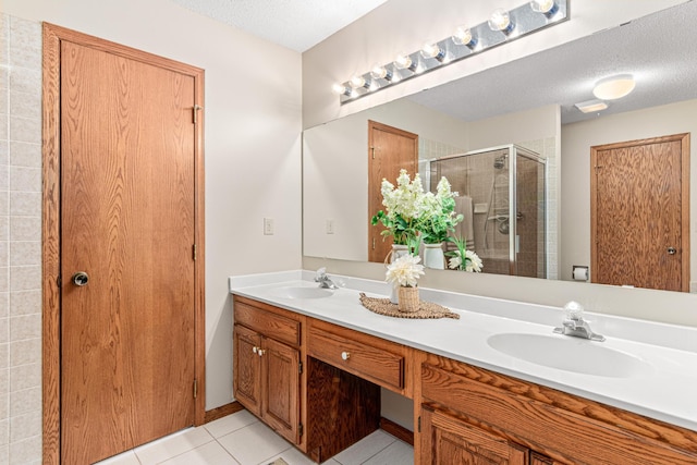 5676 Donegal Dr, Shoreview, MN 55126 - bathroom featuring double vanity, a shower stall, tile patterned floors, and a textured ceiling