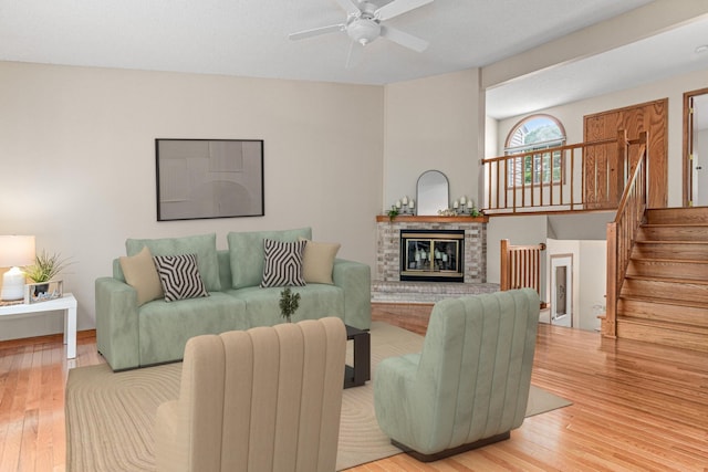 5676 Donegal Dr, Shoreview, MN 55126 - living area featuring wood finished floors, a ceiling fan, a brick fireplace, and stairs