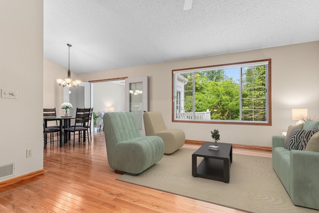 5676 Donegal Dr, Shoreview, MN 55126 - living room featuring a chandelier, wood-type flooring, baseboards, and a textured ceiling