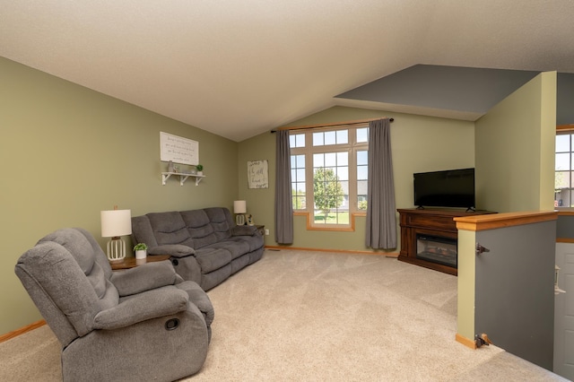 822 Emerson Ave N, Montrose, MN 55363 - living area featuring light carpet, vaulted ceiling, baseboards, and a glass covered fireplace