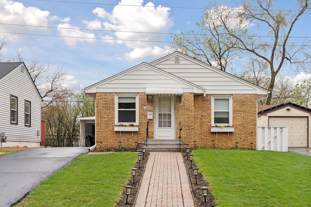 2920 Blackstone Ave, Saint Louis Park, MN 55416 - bungalow-style house with brick siding, an outbuilding, a front yard, and concrete driveway