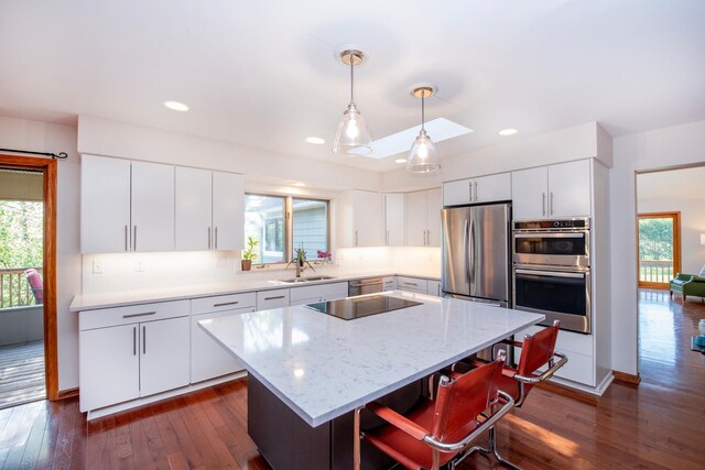 kitchen with a sink, appliances with stainless steel finishes, healthy amount of natural light, a center island, and recessed lighting