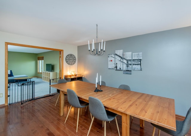 dining space with dark wood finished floors, a chandelier, and baseboards