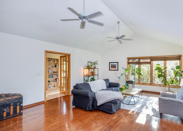 living room featuring a ceiling fan, wood finished floors, baseboards, and high vaulted ceiling