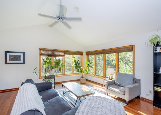 living room featuring healthy amount of natural light, wood finished floors, a ceiling fan, baseboards, and high vaulted ceiling