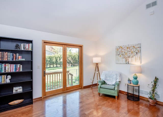 sitting room with hardwood / wood-style flooring, vaulted ceiling, and baseboards