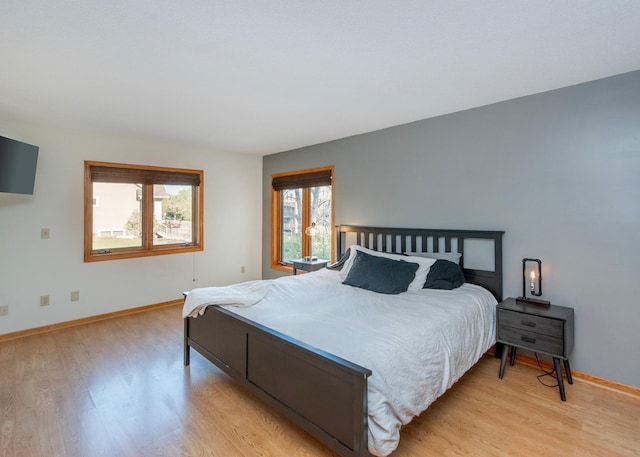 bedroom with light wood-style flooring and baseboards