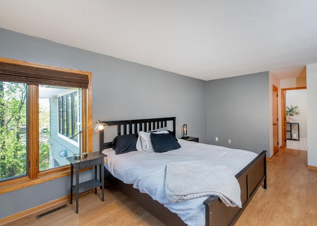 bedroom with light wood finished floors and baseboards