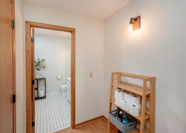 hallway featuring baseboards and light wood-style flooring